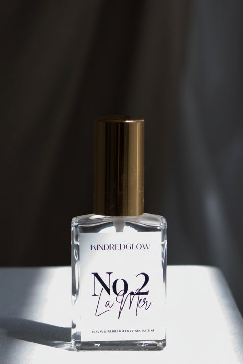 Perfume bottle labeled 'No. 2' on a white surface with a dark curtain background