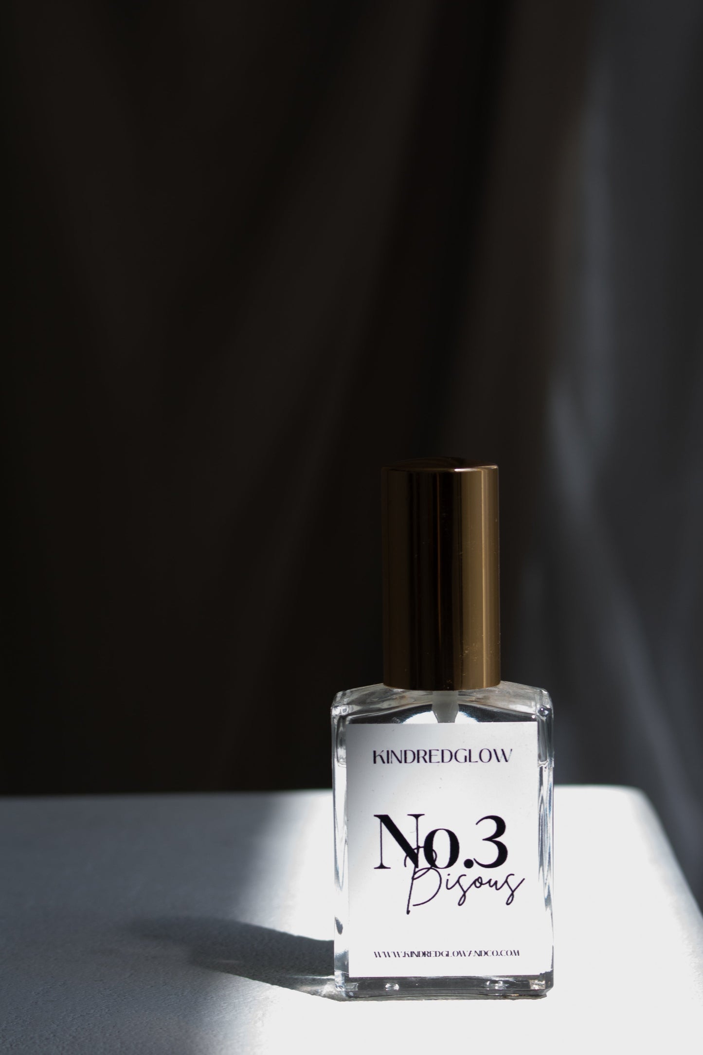 Perfume bottle labeled 'No.3' on a white surface with a dark background