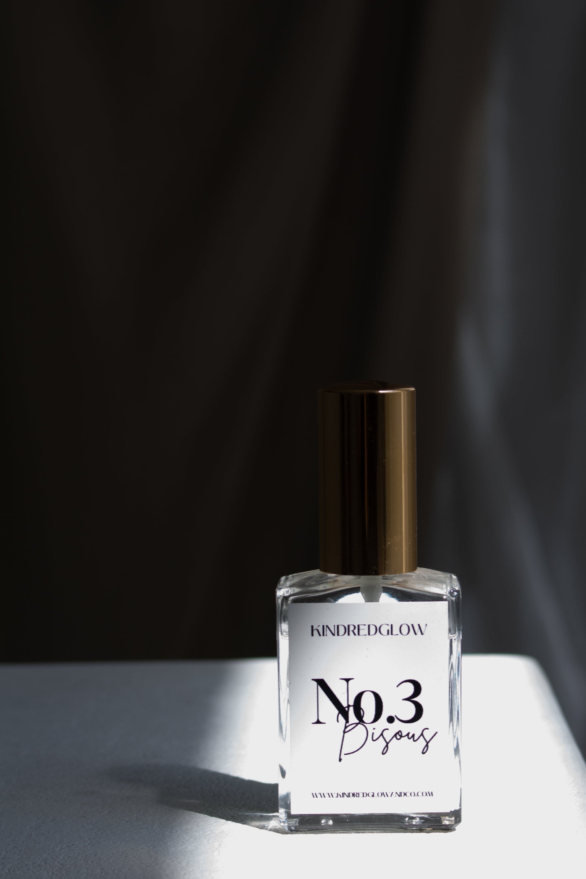 Perfume bottle labeled 'No.3' on a white surface with a dark background