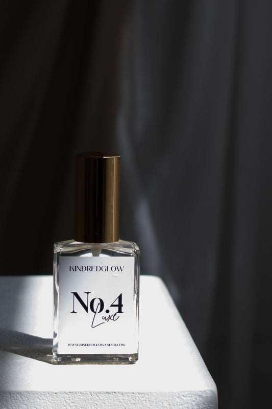 Clear glass bottle with label on a white surface against a black curtain